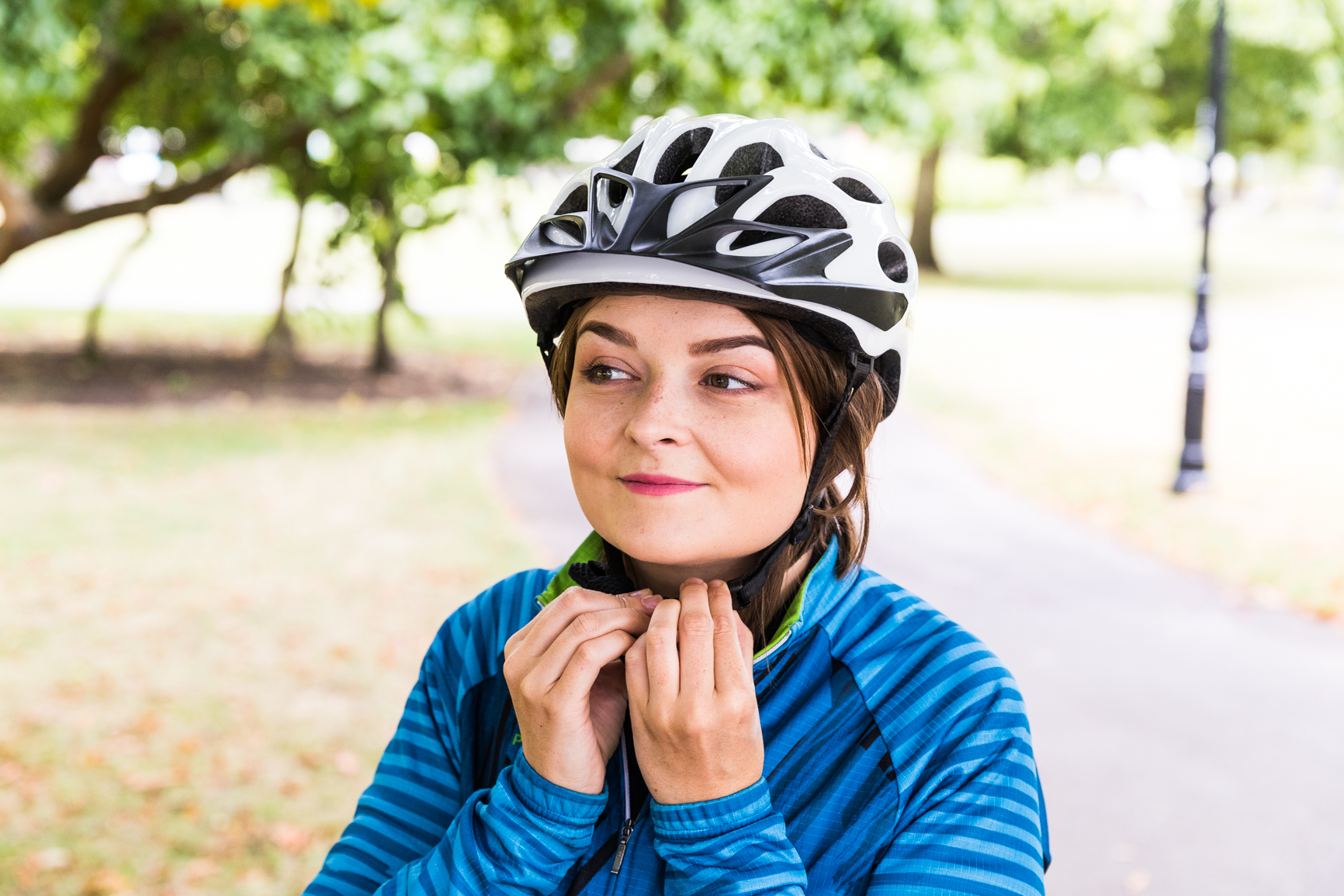 Woman cyclist clipping helmet